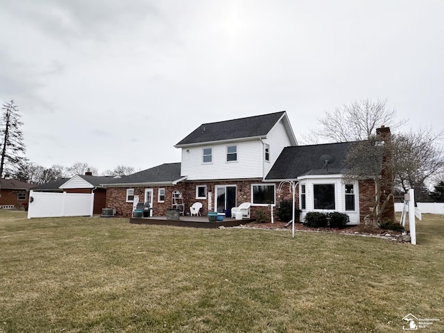 rear view of property with a patio, a lawn, and central air condition unit