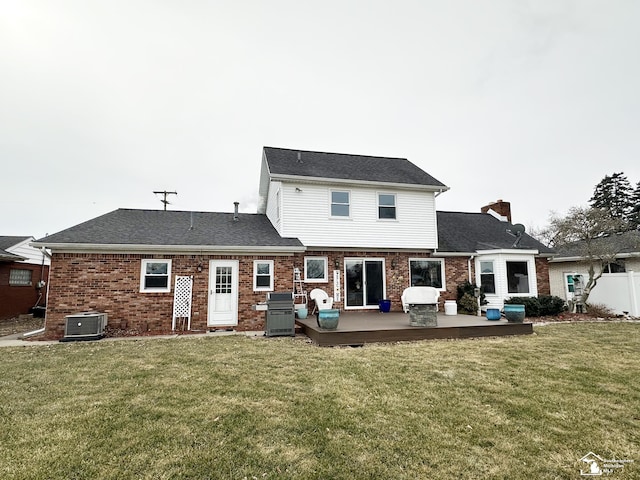 rear view of property featuring a wooden deck, a lawn, and central air condition unit