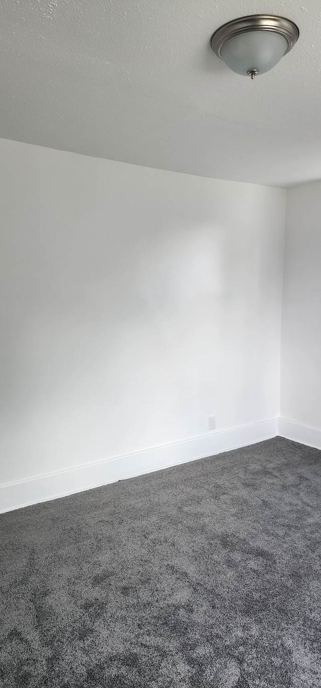 carpeted empty room featuring a textured ceiling