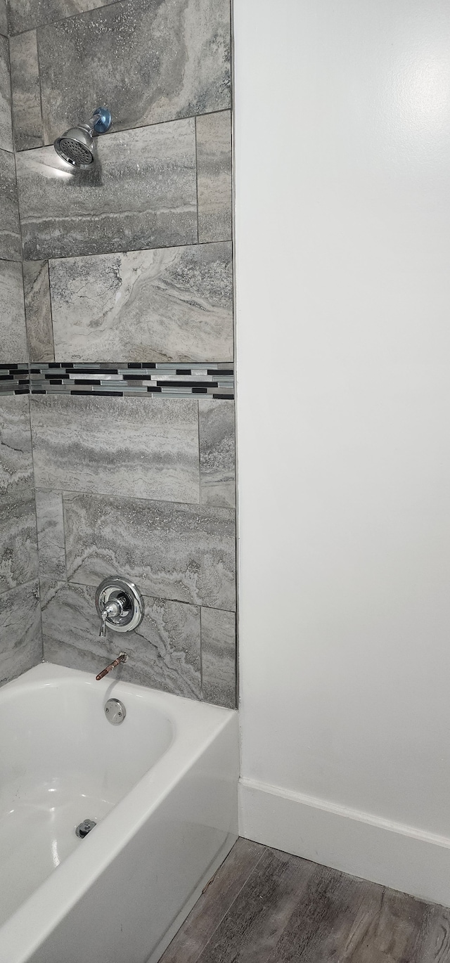 bathroom with tiled shower / bath combo and hardwood / wood-style flooring