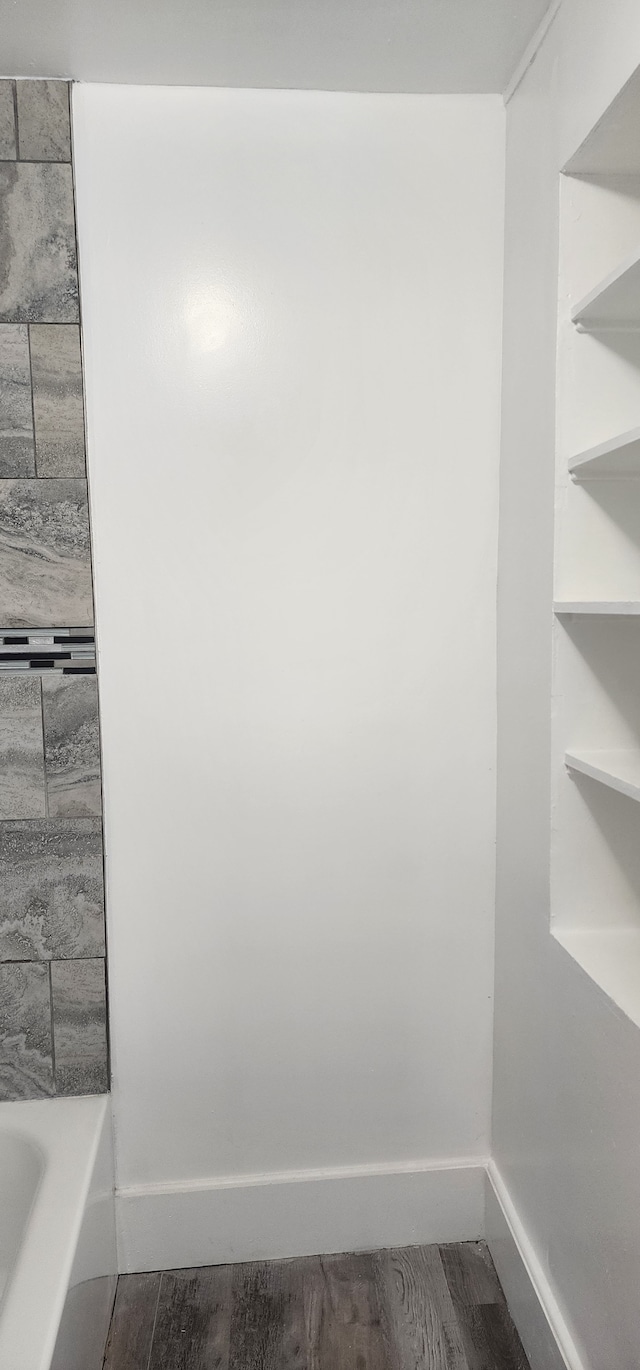 bathroom featuring hardwood / wood-style flooring and a bath