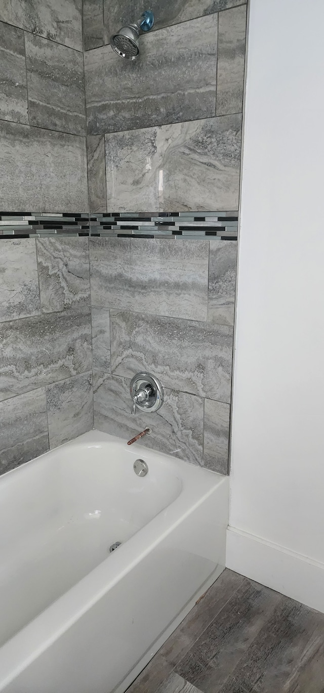 bathroom with tiled shower / bath and hardwood / wood-style floors