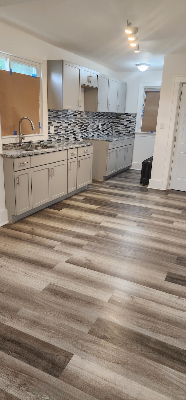 kitchen featuring tasteful backsplash, sink, and light hardwood / wood-style flooring