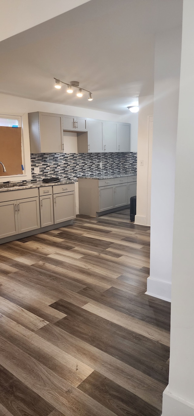 kitchen with gray cabinets, dark wood-type flooring, and decorative backsplash