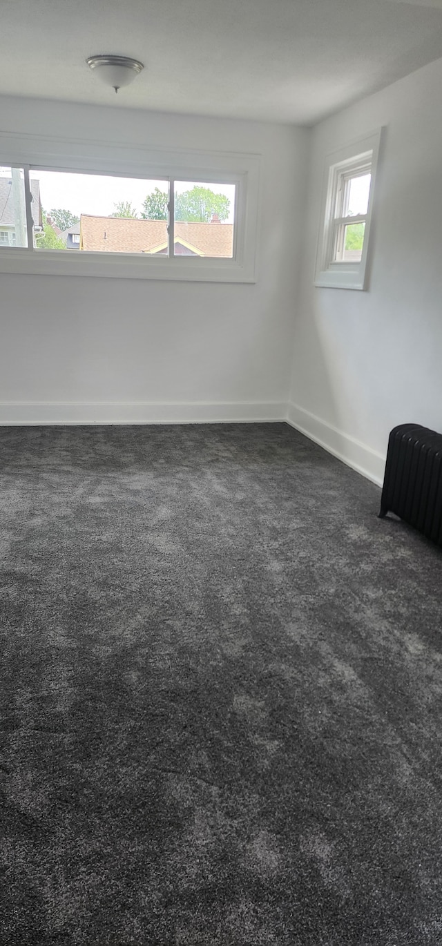 empty room featuring dark carpet