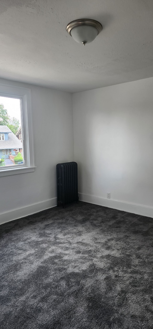 carpeted spare room featuring a textured ceiling