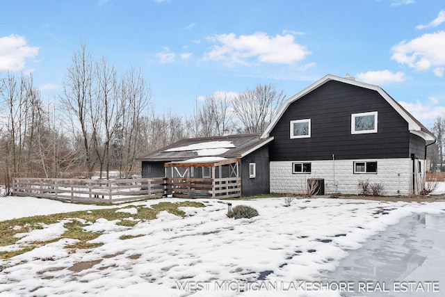 snow covered property featuring an outdoor structure