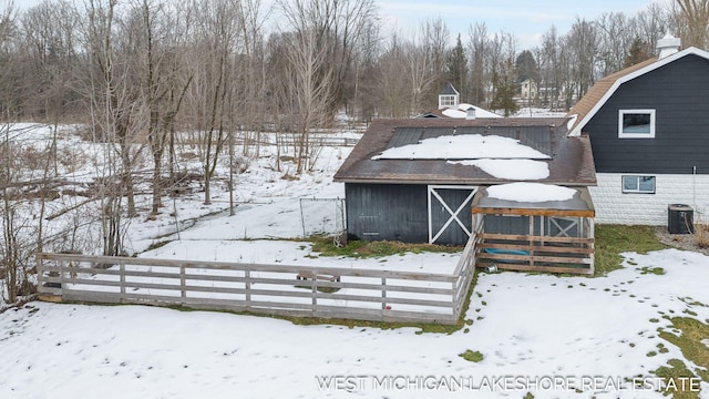 snow covered rear of property with cooling unit