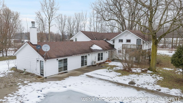 view of snow covered back of property