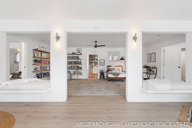 interior space featuring crown molding, ceiling fan, and light hardwood / wood-style flooring