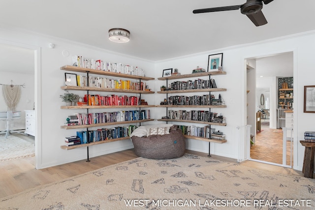 sitting room with crown molding, ceiling fan, and light hardwood / wood-style floors