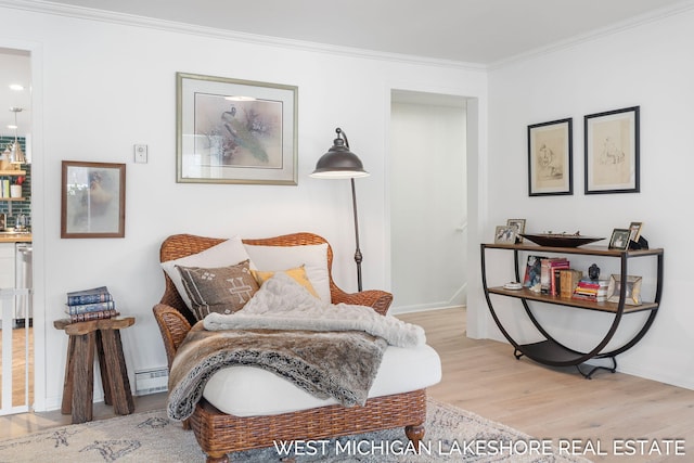 sitting room featuring crown molding, light wood-type flooring, and baseboard heating