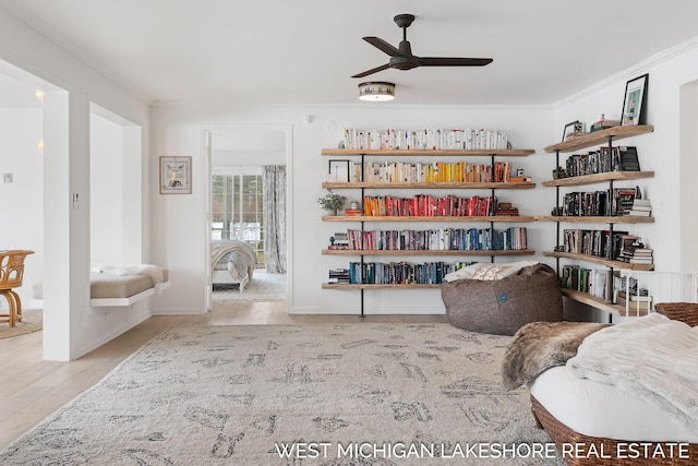 sitting room featuring ceiling fan, ornamental molding, and light hardwood / wood-style floors