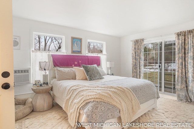 bedroom with multiple windows, access to exterior, and a wall unit AC