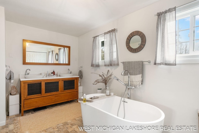 bathroom featuring vanity and a tub to relax in