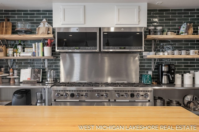 kitchen with stainless steel appliances, white cabinetry, and tasteful backsplash