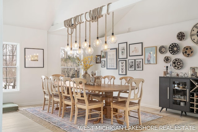 dining area with lofted ceiling, light wood-type flooring, and plenty of natural light