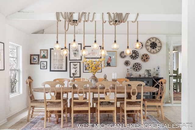 dining space featuring hardwood / wood-style flooring and vaulted ceiling