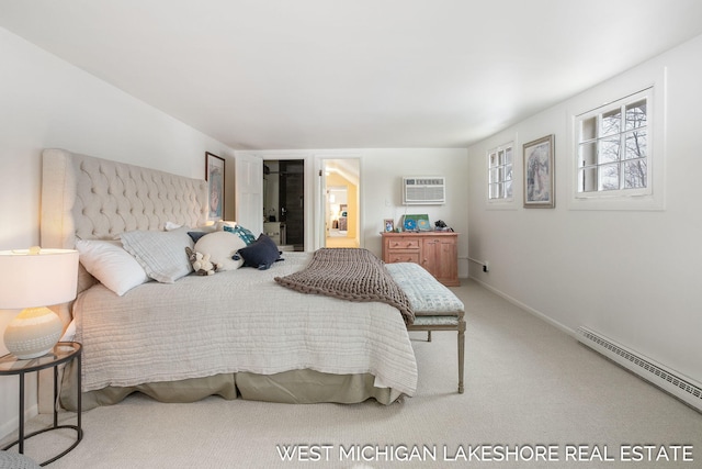 bedroom with an AC wall unit, a baseboard heating unit, and carpet flooring