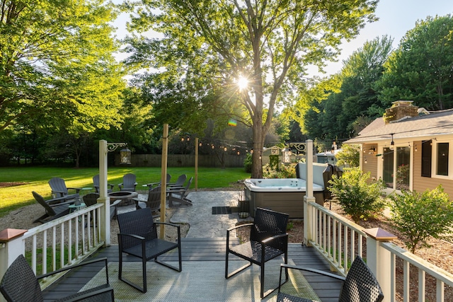 deck with a yard, a hot tub, and an outdoor fire pit