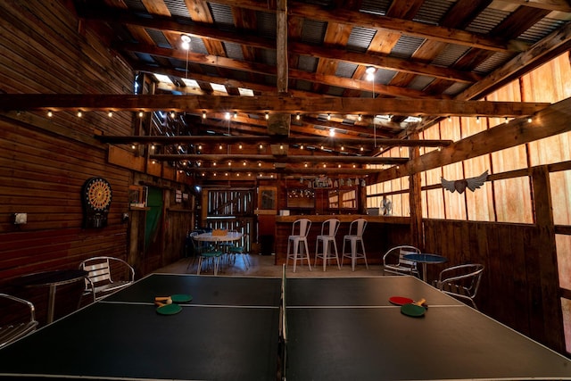 recreation room featuring bar and wooden walls