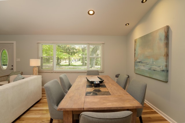 dining area with lofted ceiling and light hardwood / wood-style flooring