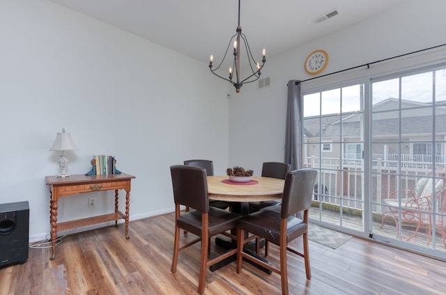 dining room with hardwood / wood-style floors and a notable chandelier