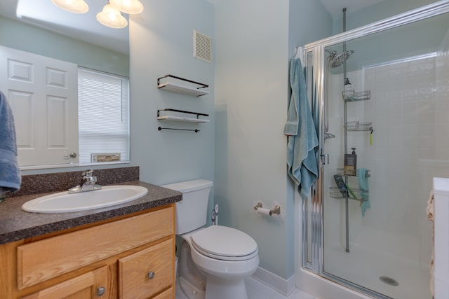 bathroom with vanity, tile patterned flooring, toilet, and walk in shower