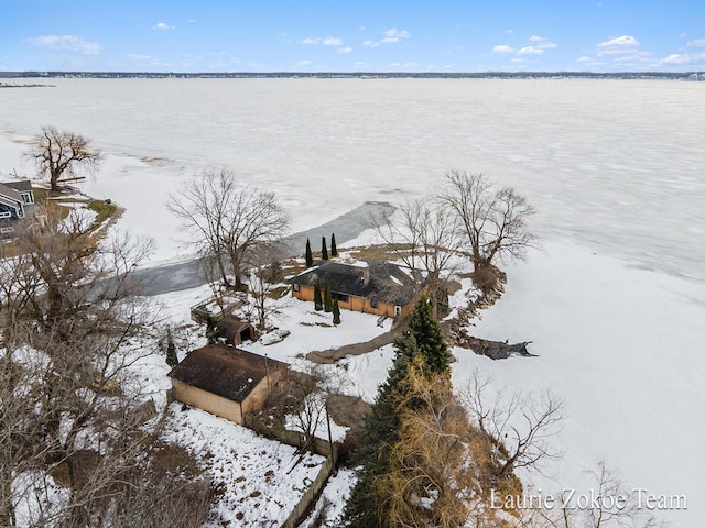 snowy aerial view with a water view