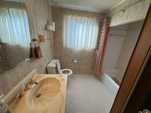 full bathroom featuring sink, shower / bath combination with curtain, toilet, crown molding, and a textured ceiling