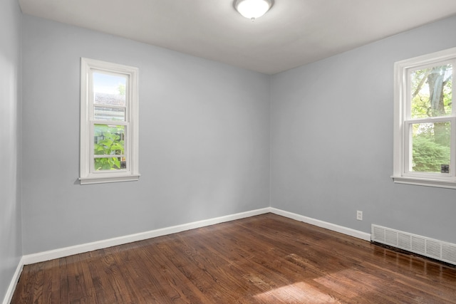 unfurnished room with dark wood-type flooring