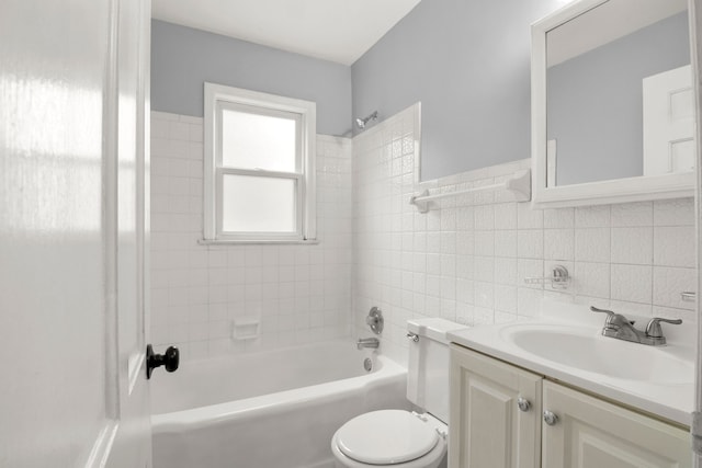 full bathroom with vanity, tiled shower / bath, tile walls, and toilet