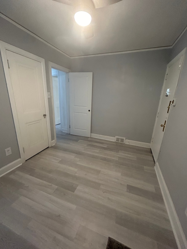 unfurnished room with crown molding and light hardwood / wood-style flooring