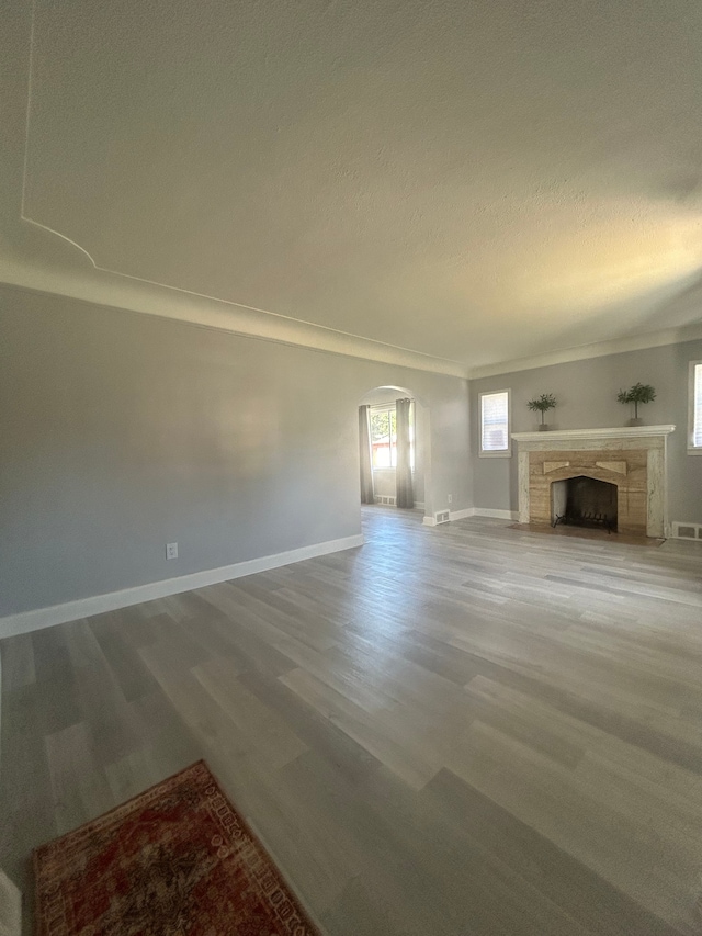 unfurnished living room featuring hardwood / wood-style floors and a textured ceiling