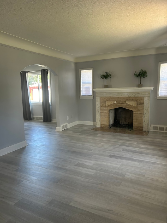 unfurnished living room with hardwood / wood-style floors and a textured ceiling