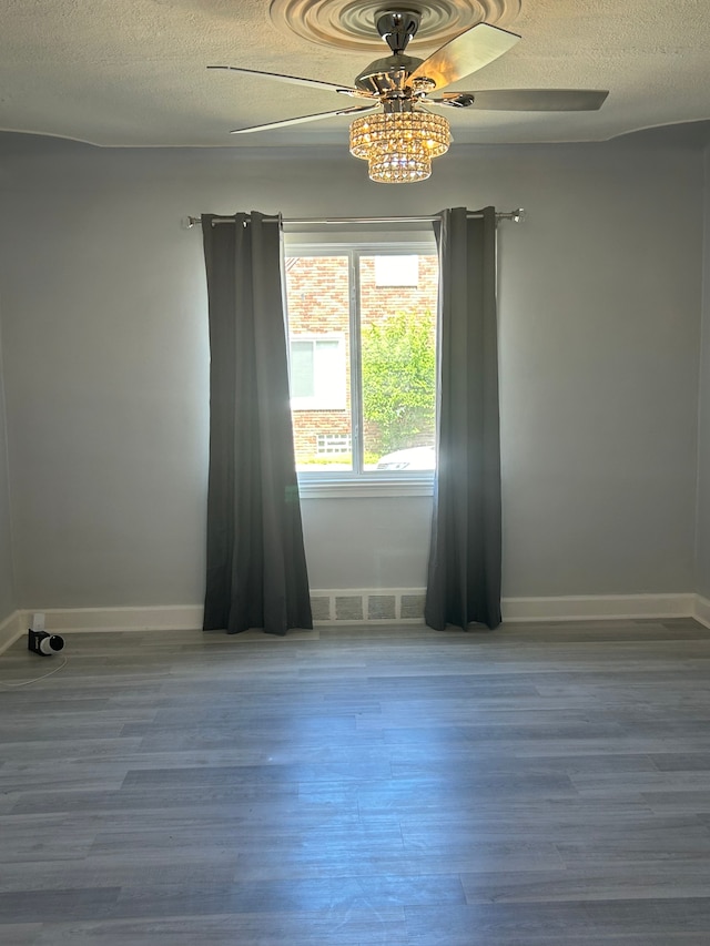 unfurnished room featuring hardwood / wood-style flooring, ceiling fan, and a textured ceiling