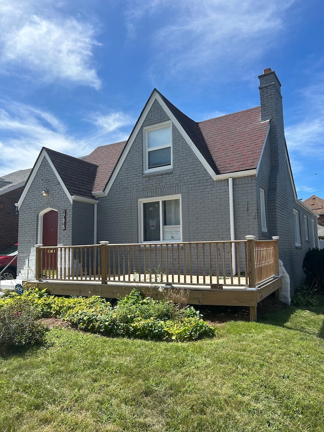 rear view of house featuring a yard and a deck