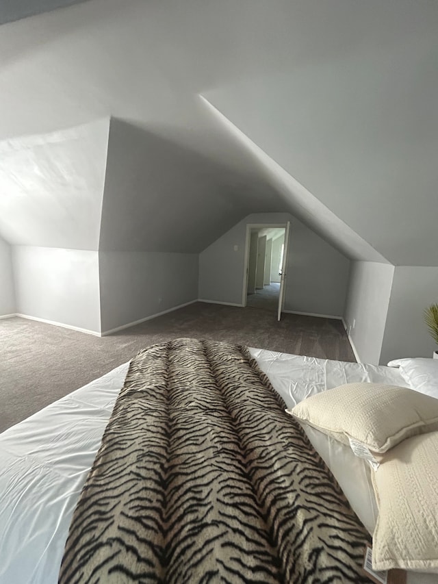 bedroom with vaulted ceiling and dark colored carpet