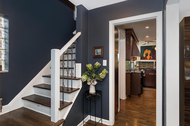 stairs featuring sink and hardwood / wood-style floors