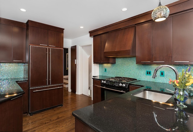 kitchen featuring sink, custom exhaust hood, paneled refrigerator, black range with gas stovetop, and pendant lighting