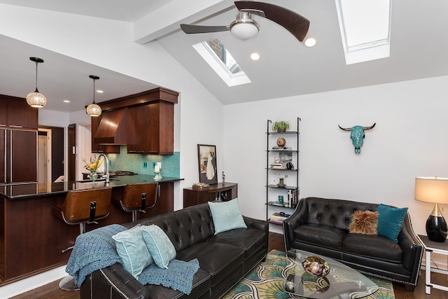 living room with dark hardwood / wood-style floors, ceiling fan, lofted ceiling with skylight, and sink