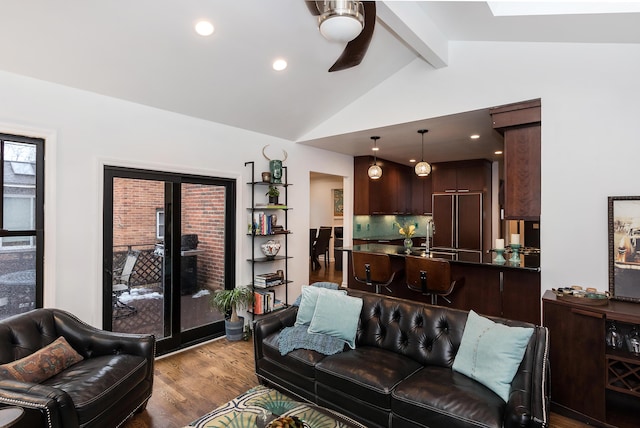 living room featuring vaulted ceiling with beams, hardwood / wood-style flooring, and sink