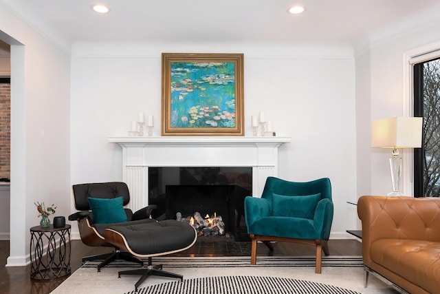 living area with crown molding and hardwood / wood-style floors