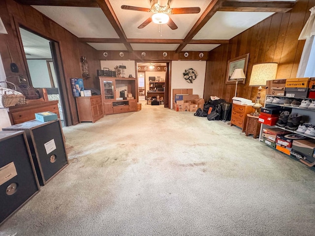 interior space with coffered ceiling, beam ceiling, carpet, and wood walls