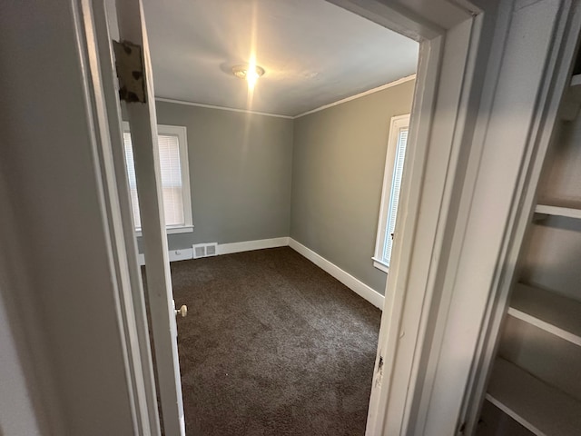 empty room with ornamental molding and carpet