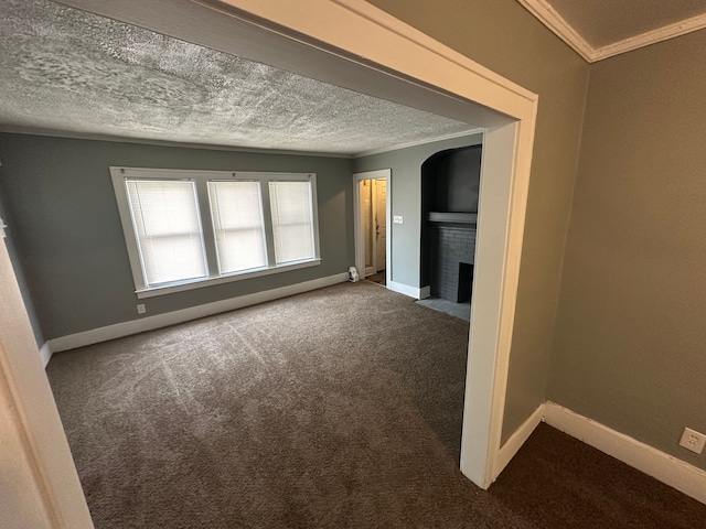 carpeted empty room featuring ornamental molding, a fireplace, and a textured ceiling