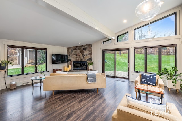 living room with dark hardwood / wood-style floors, a fireplace, beam ceiling, and a wealth of natural light