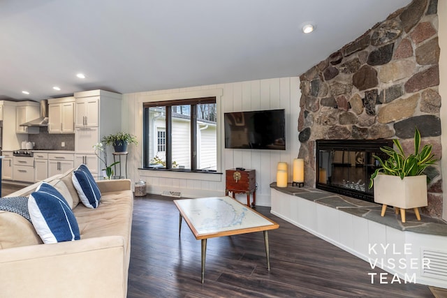 living room featuring dark wood-type flooring and a fireplace