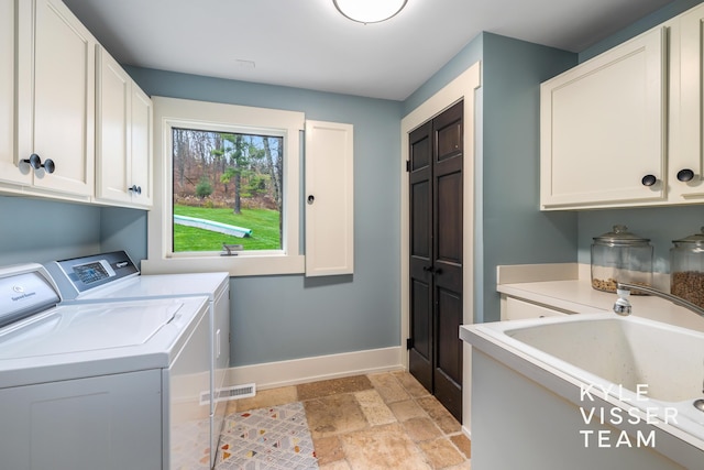 laundry room with cabinets, sink, and washer and clothes dryer