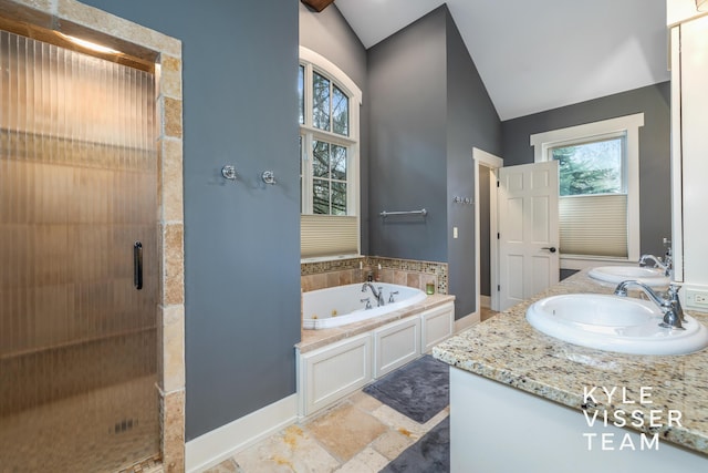 bathroom featuring independent shower and bath, vaulted ceiling, and vanity